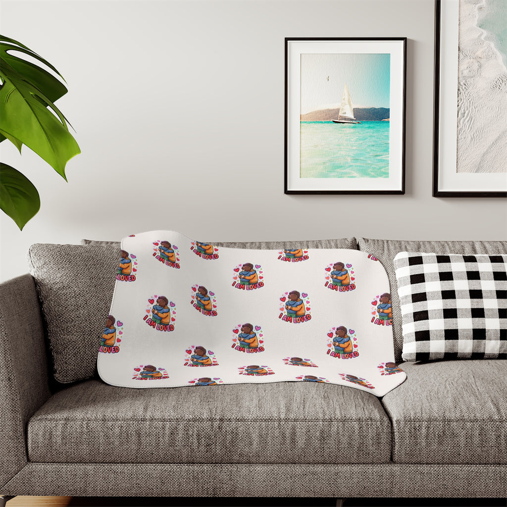 I Am Loved sherpa blanket with a repeating pattern of children hugging and hearts on cream